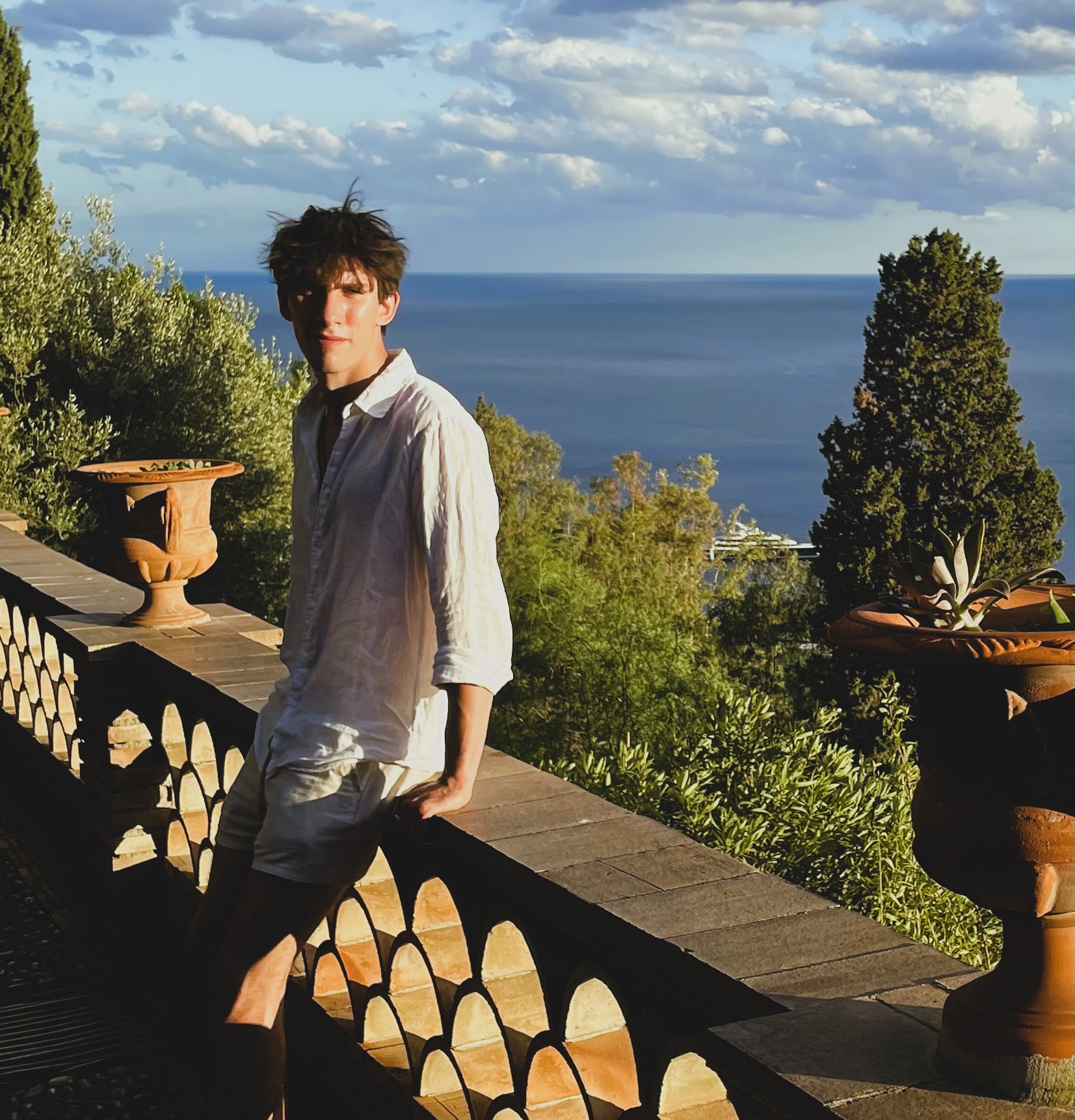 A picture of the website's author, Andreas, leaning against a low stone wall in Italy